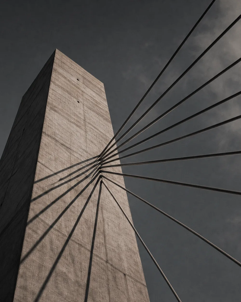 The cable stays of a bridge seen from directly below against the sky.